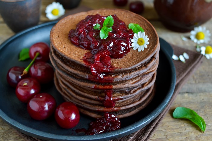 Stack of Chocolate Pancakes with Cherry Jam and Cherries