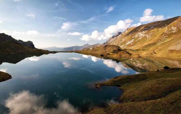 Lake and mountains reflecting in the water under a blue sky