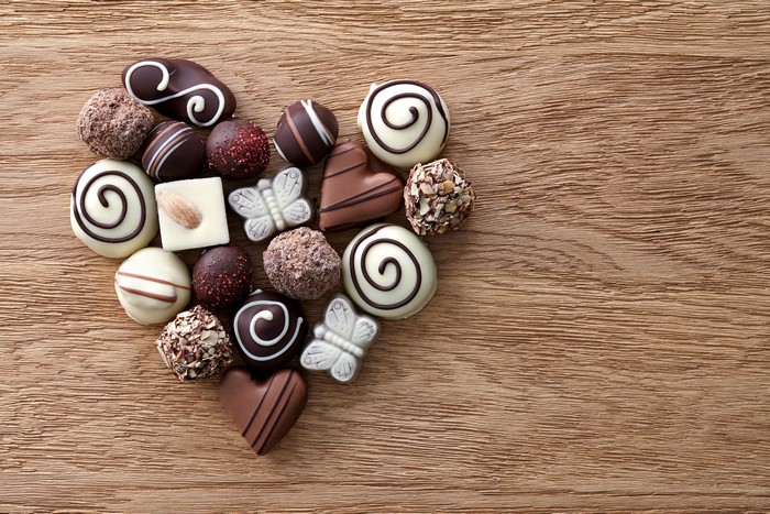 Heart shape of assorted chocolates on a wooden background