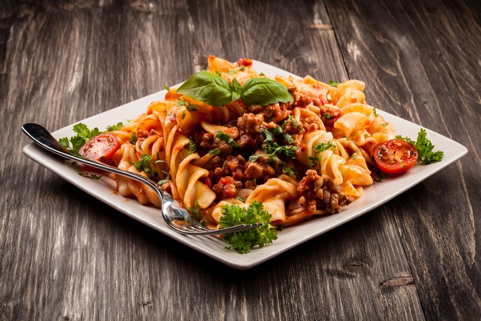 Pasta with meat sauce on a plate with a fork