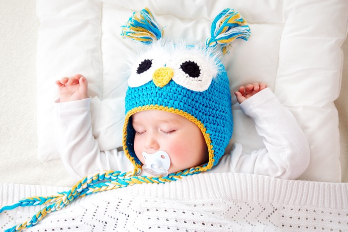 Baby sleeping with owl hat