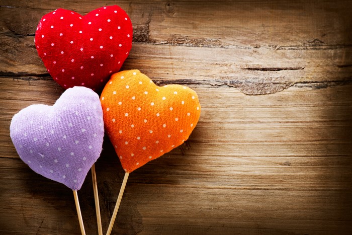 Three polka dot hearts on wood planks
