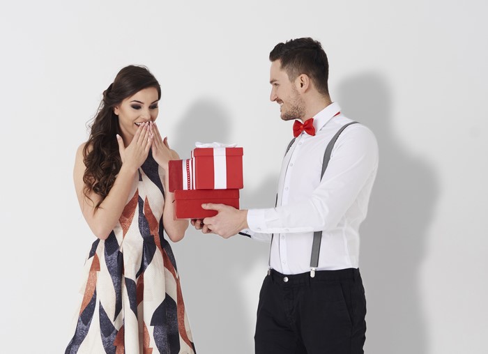 Man giving gifts to surprised woman
