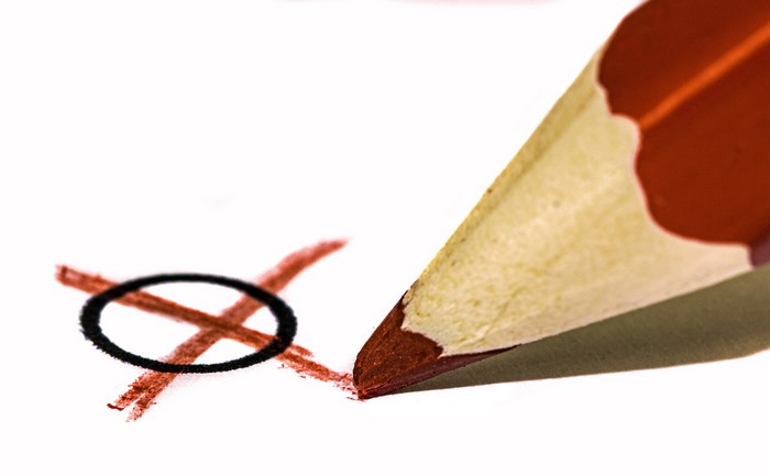 Pencil marking a ballot with an X and circle