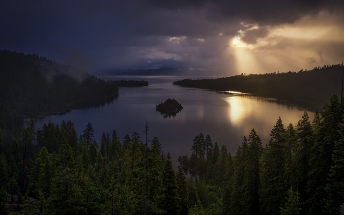 Lake with an island and sunbeams through clouds