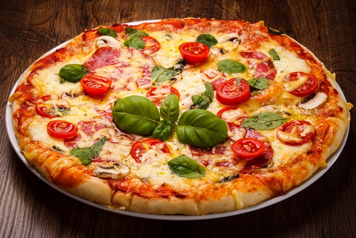 Pizza with Tomatoes, Basil, and Mushrooms on Wood