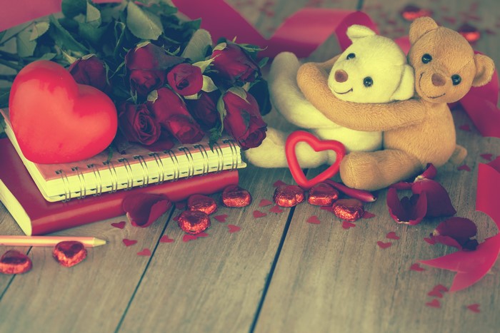 Teddy bears, roses, and heart decorations on wood