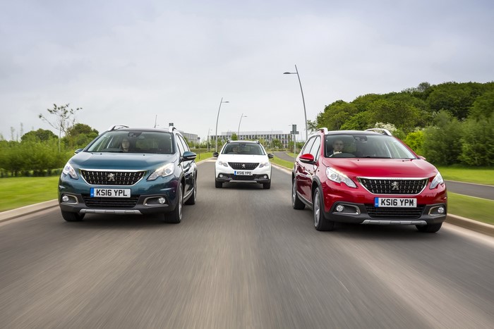 Three Peugeot 2008 cars driving on a road