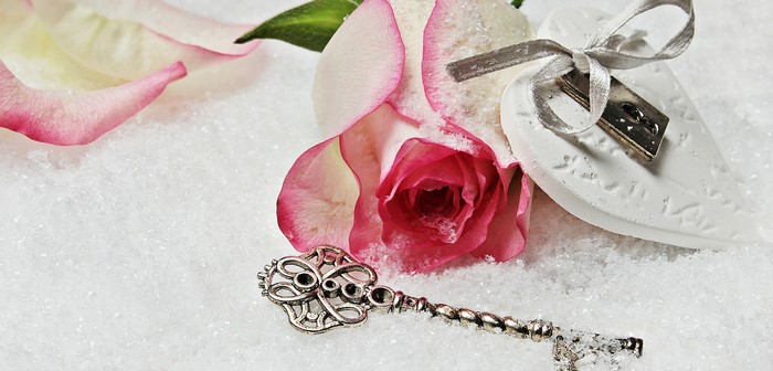 Rose with key and heart on snow