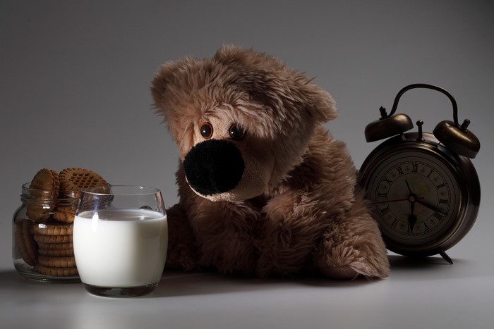 Teddy bear with milk, cookies, and alarm clock