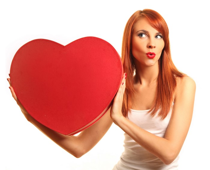 Redhead girl holding a red heart shape