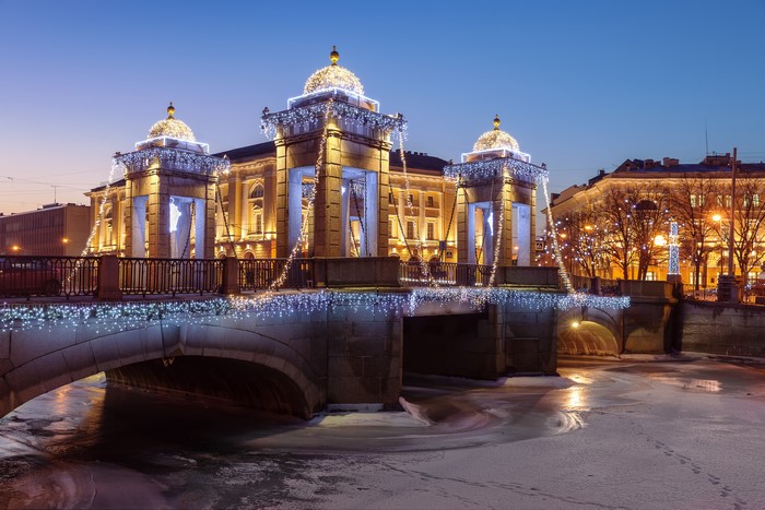 Lomonosov Bridge in St. Petersburg decorated with fairy lights in winter evening