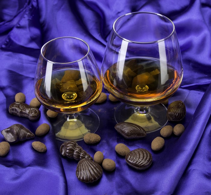Two glasses of whisky with chocolates and candies