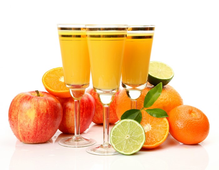 Juice in glasses with apples and oranges