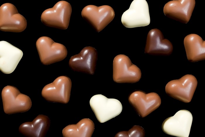 Heart-shaped chocolates on black background