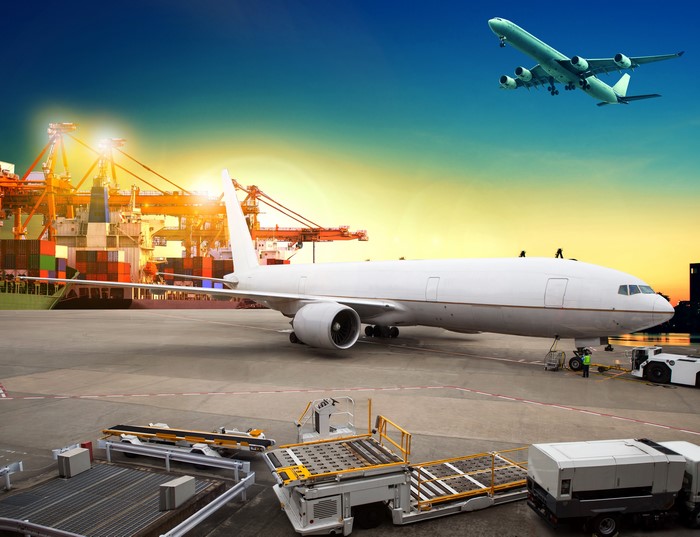 Airplane at Port with Cargo and Aircraft in Sky