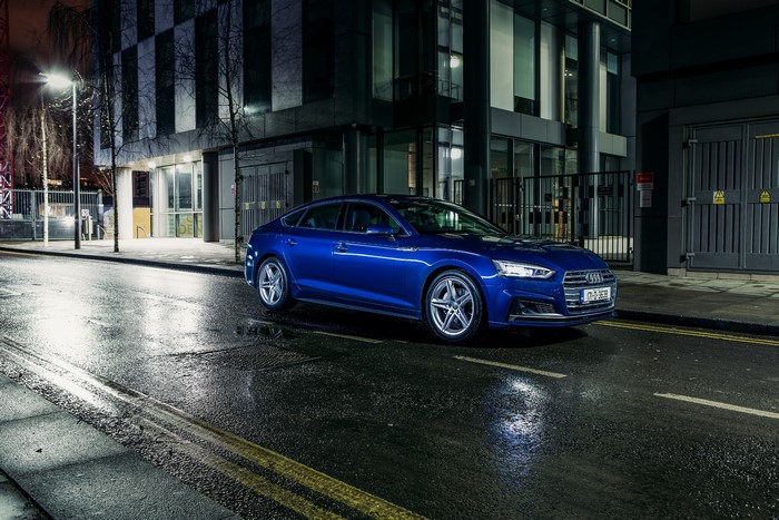 Blue 2017 Audi A5 Sportback on a wet street at night