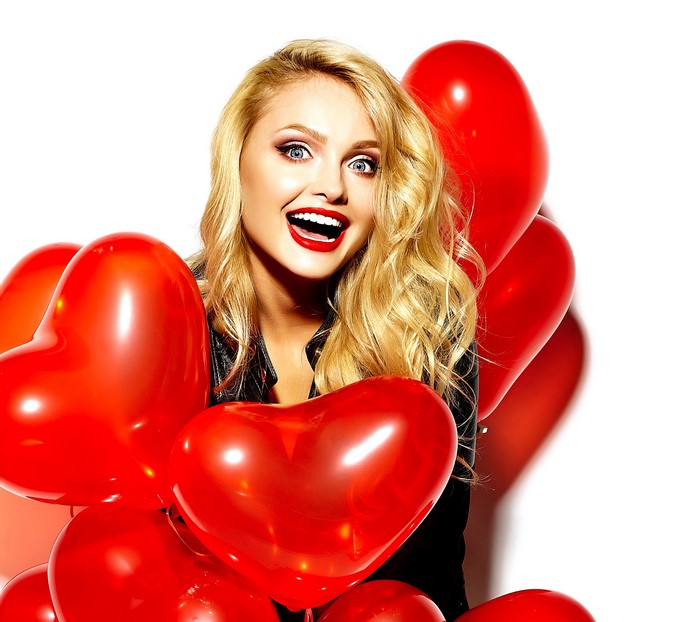 Blonde girl with red heart balloons