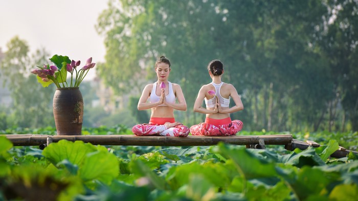 Two Asian women in Lotus position doing yoga