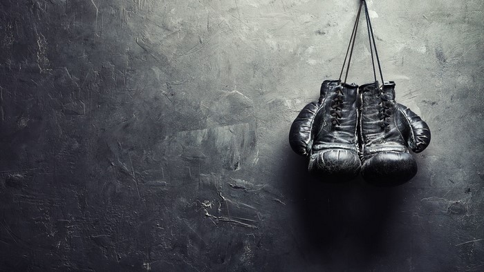 Pair of old boxing gloves hanging on a wall