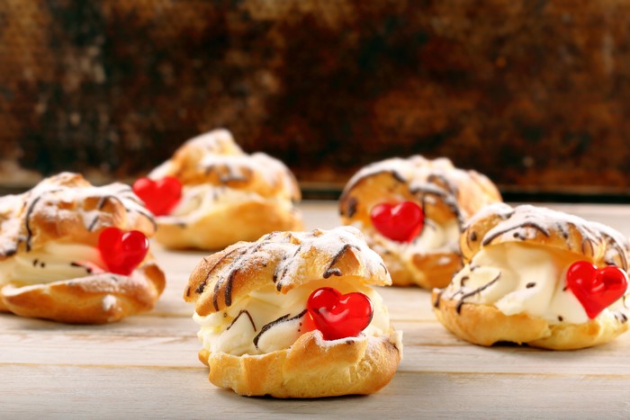 Cream puffs with chocolate drizzle and heart candies