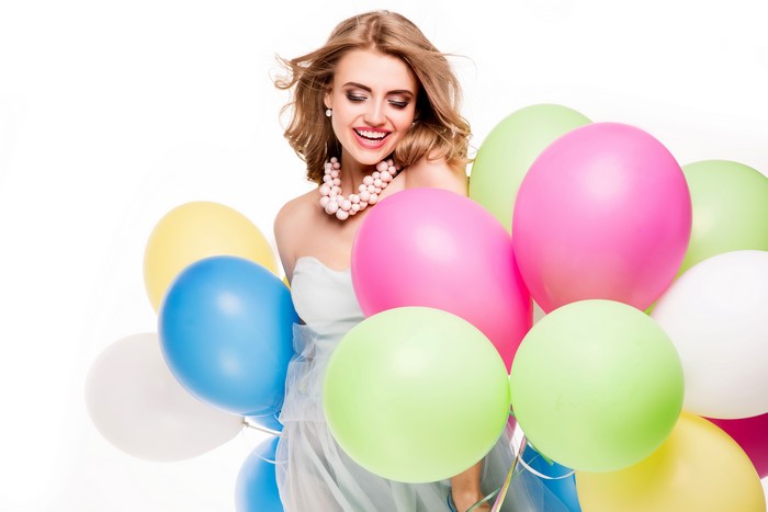 Blonde girl with balloons on white background