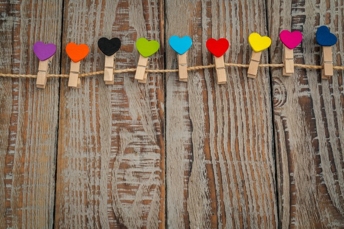 Colorful heart clothespins on a wooden background