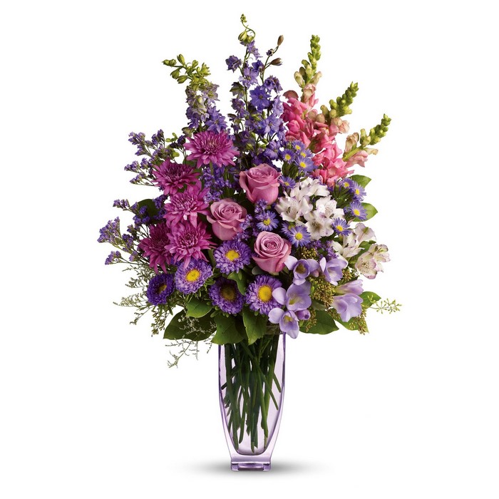 Purple and pink floral arrangement in a glass vase