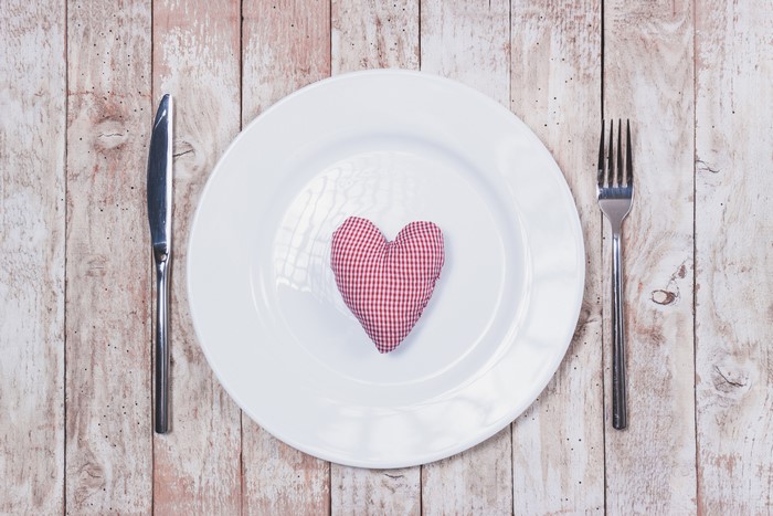 White plate with heart on wood planks