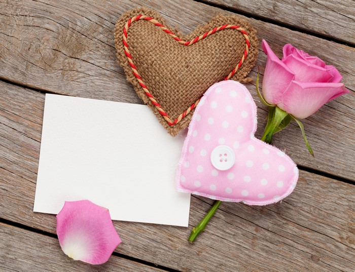 Valentine's Day hearts, rose, and blank card on wood