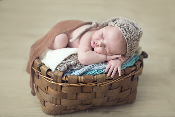 Newborn baby sleeping in a wicker basket