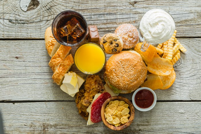 Heart shape of unhealthy food on wooden table