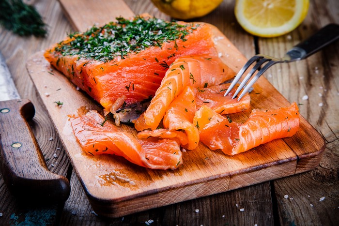 Smoked Salmon with Dill and Lemon on a Cutting Board