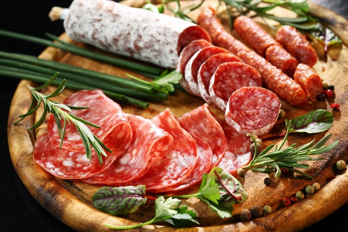 Sliced sausages and salami on a wooden board