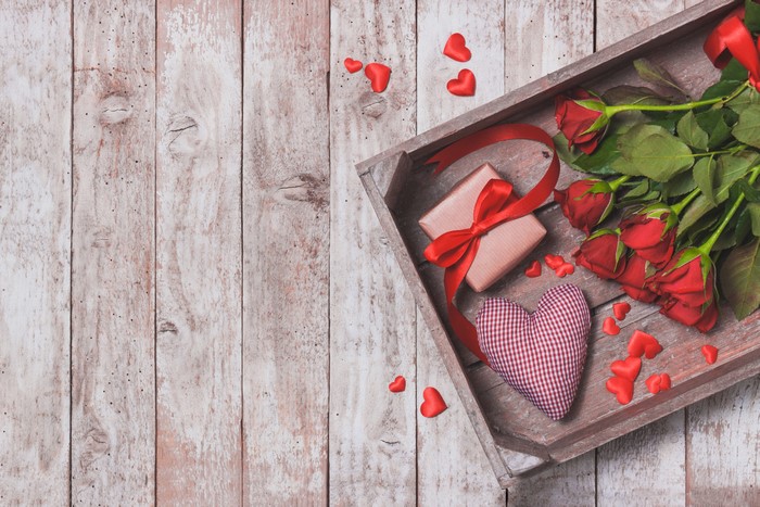 Valentine's Day roses, gift, and heart on wood planks