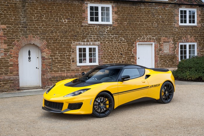 Yellow Lotus Evora Sport 410 parked in front of a brick house