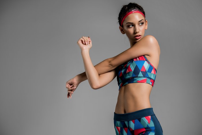 Woman in Nike headband and sports bra stretching