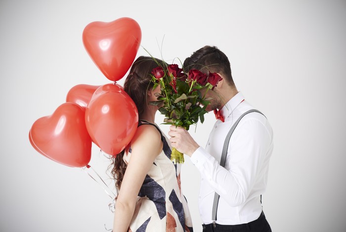 Couple with red roses and heart balloons