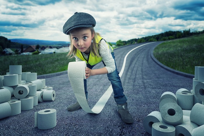 Girl with toilet paper rolls on a road