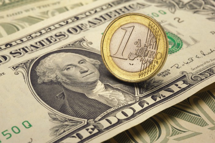 Euro coin on US Dollar banknotes