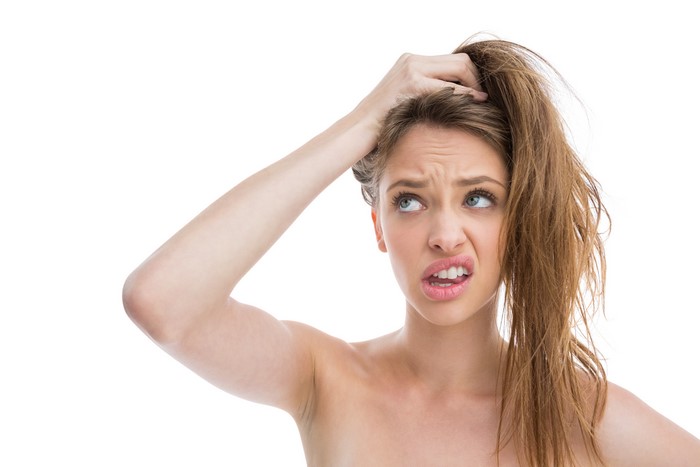 Woman scratching her head with a confused expression