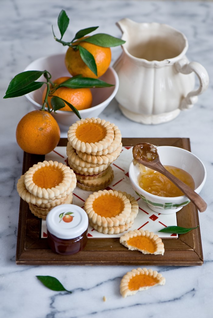 Cookies with jam and mandarines on a tray