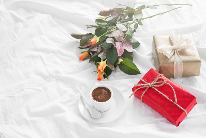 Coffee, Roses, and Gifts on a White Bed