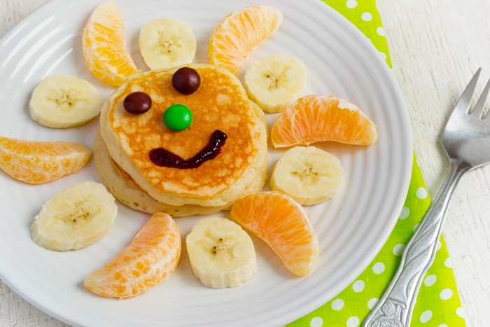 Pancake smiley face with fruit and candy