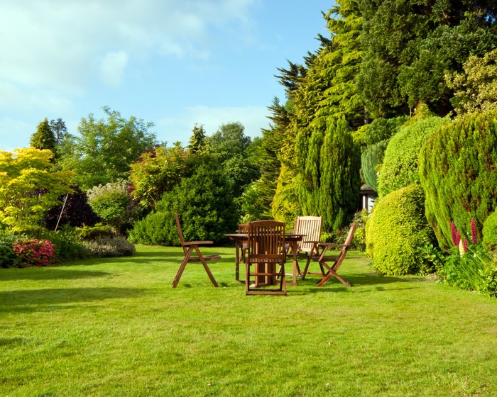 Garden with wooden table and chairs on lawn