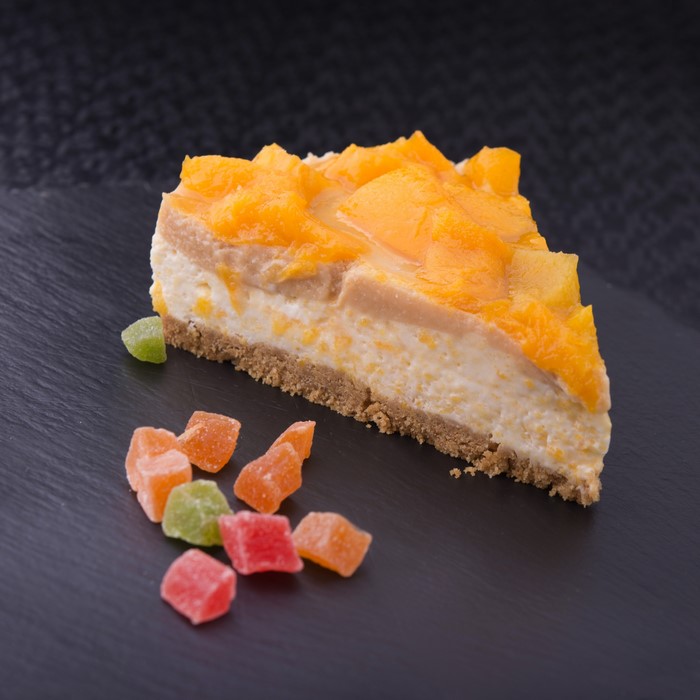 Slice of mango cheesecake with candied fruit