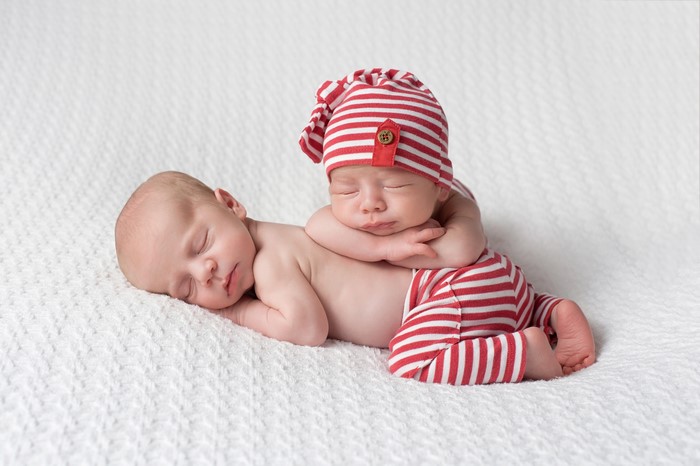 Two Newborn Babies Sleeping in Red and White Striped Outfits