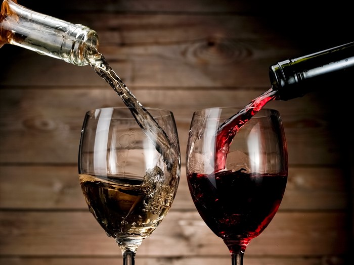 White and Red Wine Being Poured into Glasses