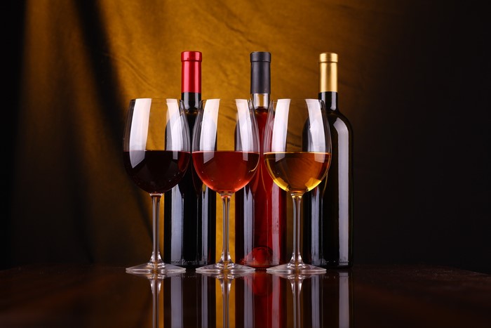 Wine bottles and glasses with red, rosé, and white wine