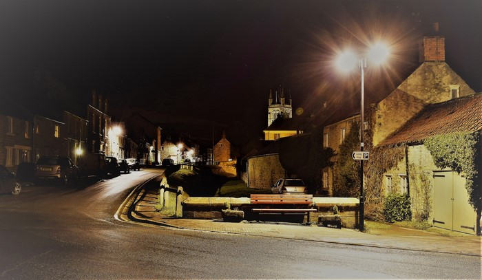 Night street scene in Helmsley, North Yorkshire, England with houses and street lights